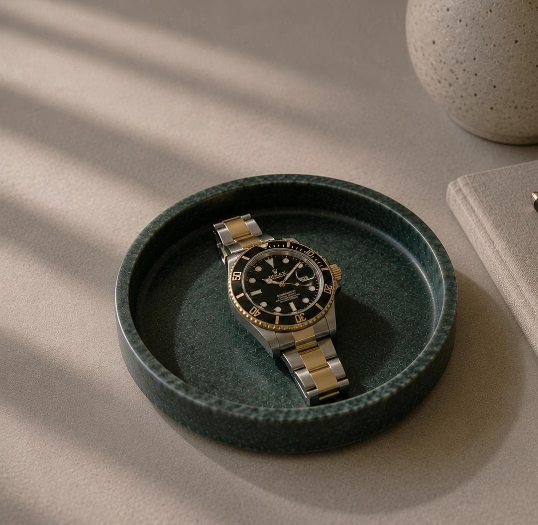 Eine Rolex Submariner Stahl/Gold liegt auf dem Tisch.